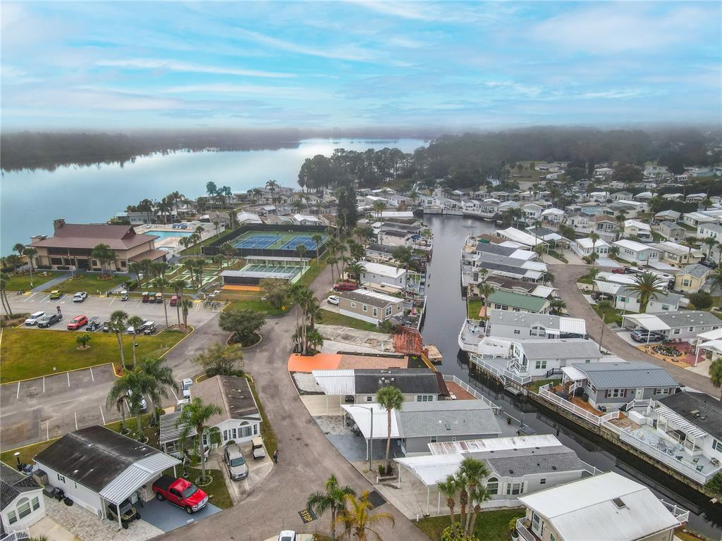 An aerial view shows a residential community with mobile homes, a canal, and tennis courts — 9000 US HWY 192 UNIT 324, CLERMONT, FL