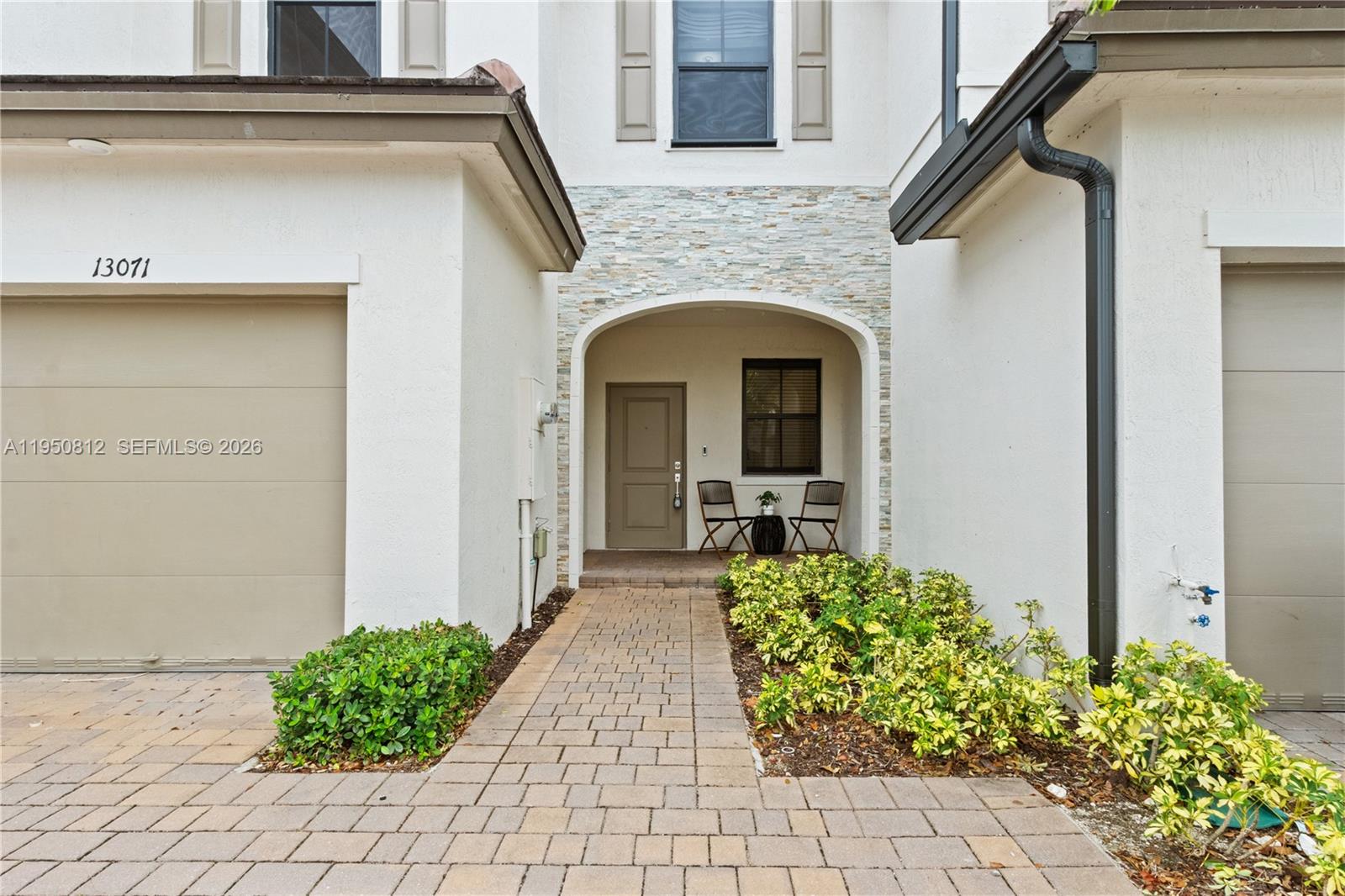 A paved walkway leads to the recessed front entrance of a two-story stucco home — 13071 SW 232nd Ln, Miami FL 33170, MIAMI, FL
