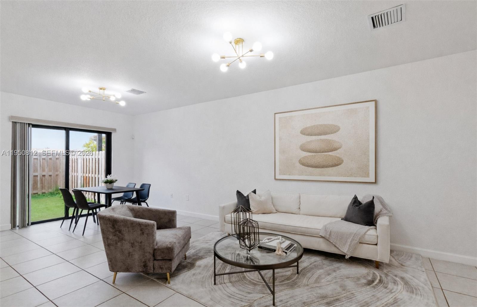 A living and dining area features white walls, tile floors, and a sliding glass door — 13071 SW 232nd Ln, Miami FL 33170, MIAMI, FL