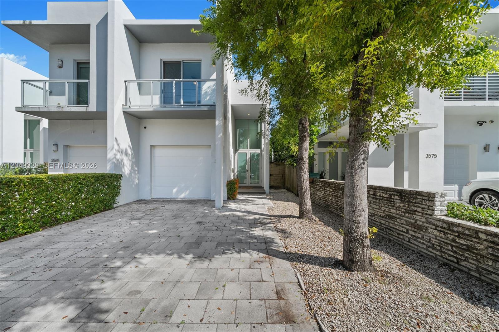 A modern two-story white townhouse features a paved driveway, a garage, and a balcony — 3567 SW 1st Ave # 3567, Miami FL 33145, MIAMI, FL