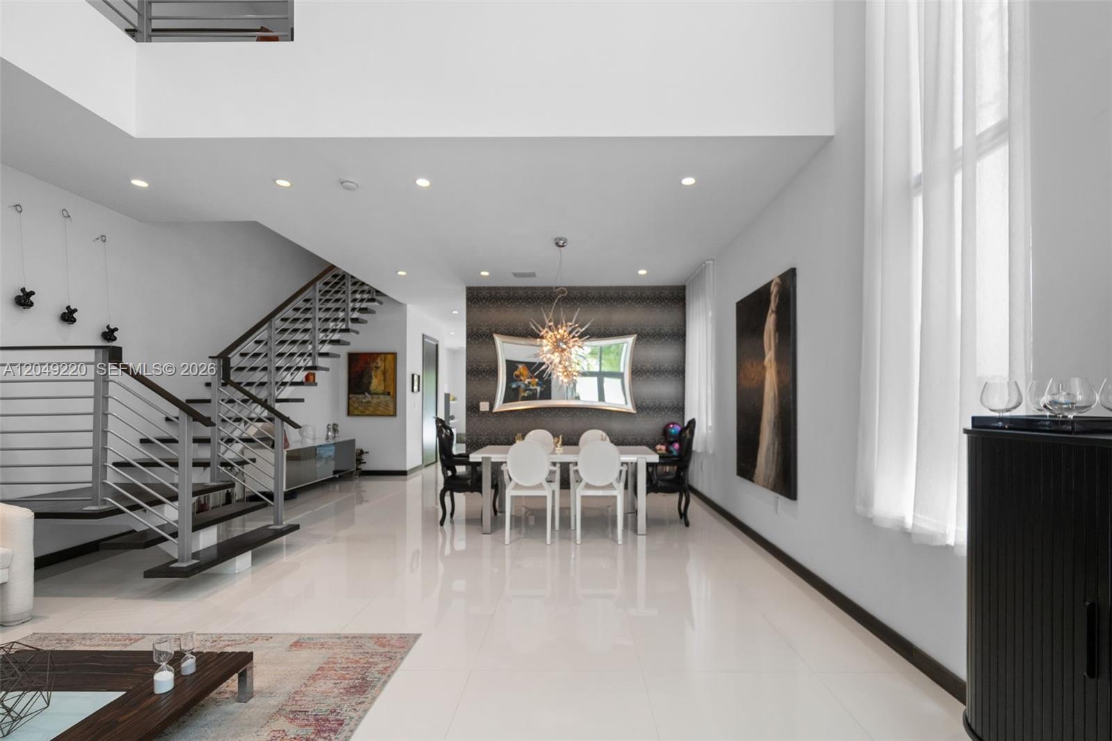 A modern dining area features a white table, white chairs, and a floating staircase — 3567 SW 1st Ave # 3567, Miami FL 33145, MIAMI, FL