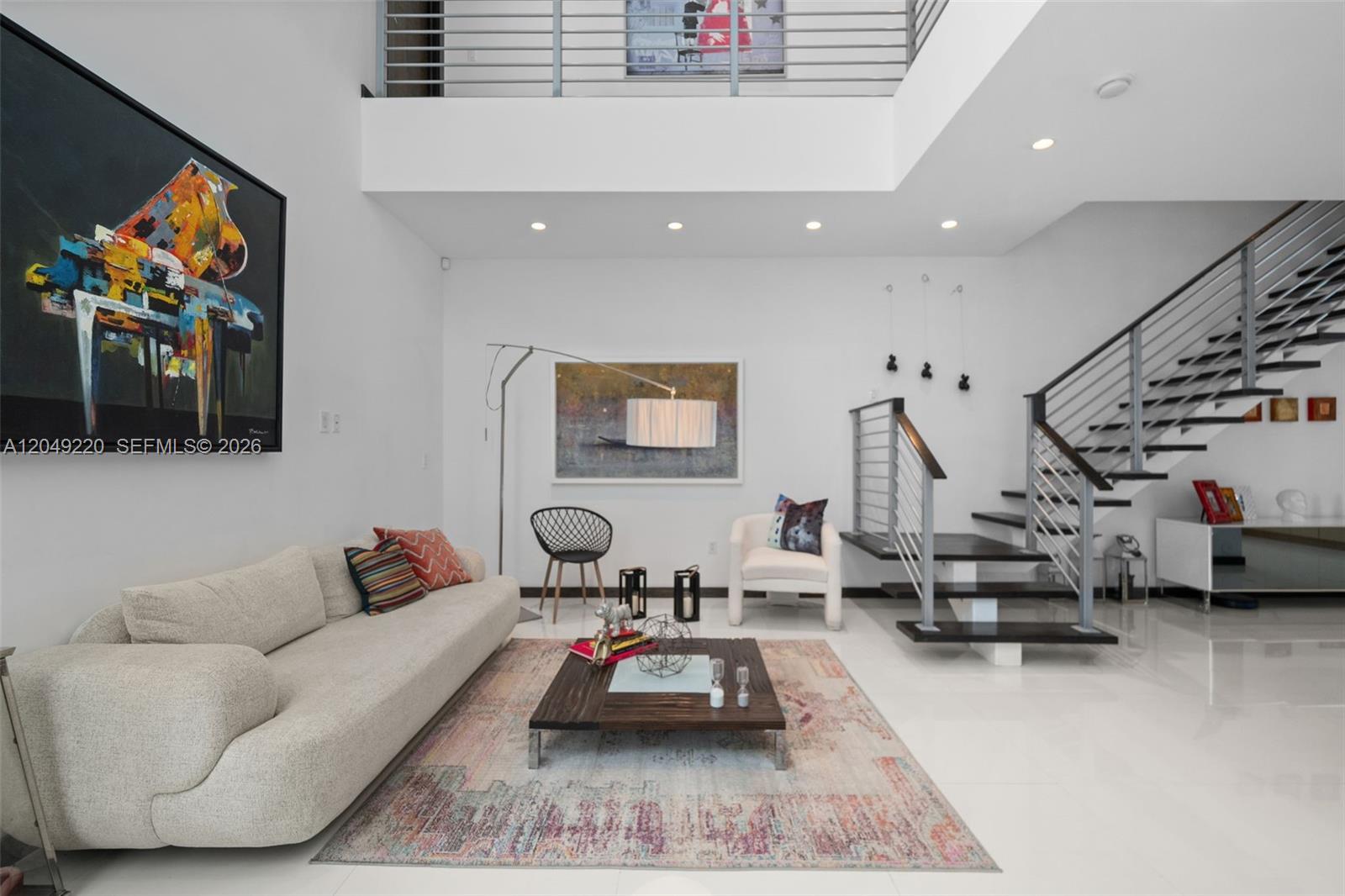 A modern living room features a high ceiling, a floating staircase, and abstract wall art — 3567 SW 1st Ave # 3567, Miami FL 33145, MIAMI, FL