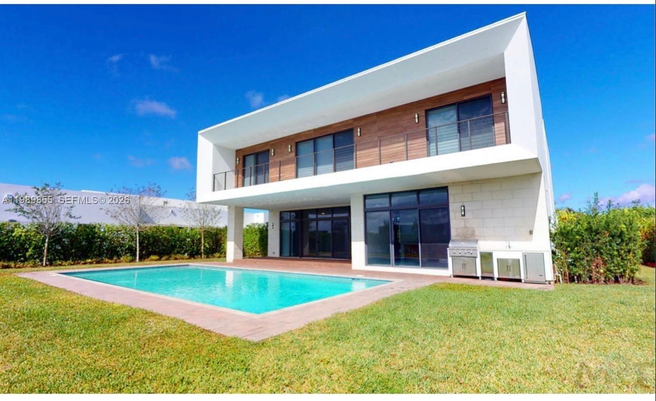 A modern two-story house with a wooden facade, a balcony, and a backyard swimming pool — 16580 Sunset Way # 16580, Weston FL 33326, WESTON, FL