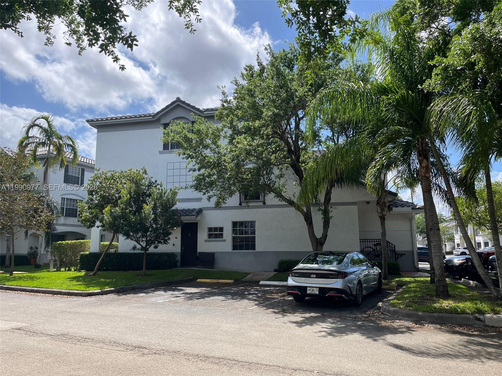 A two-story residential building with a silver sedan parked in front — 781 SW 148th Ave # 1502, Sunrise FL 33325, SUNRISE, FL
