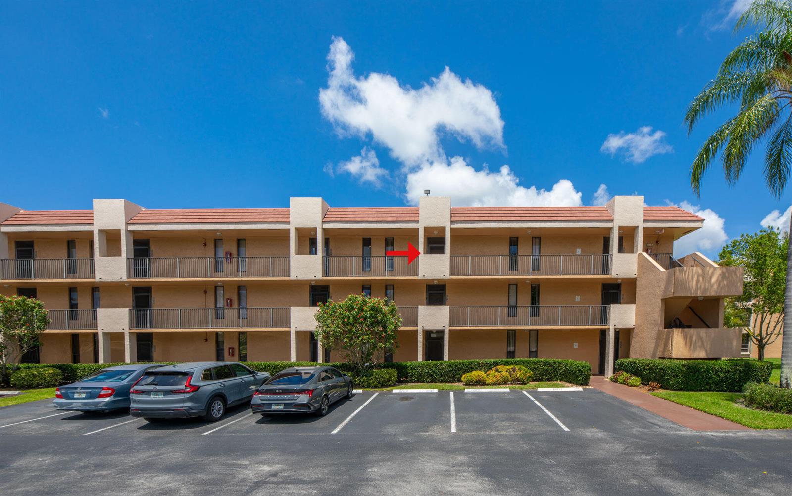 A three-story apartment building with a red tile roof and a red arrow pointing upward — 5926 Coral Lake Drive # 302, Margate FL 33063, MARGATE, FL
