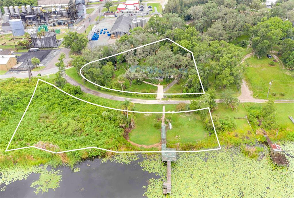 An aerial view shows two parcels of land with a house, trees, and a dock — 490 TWIN LAKES BOULEVARD, LAKE ALFRED, FL