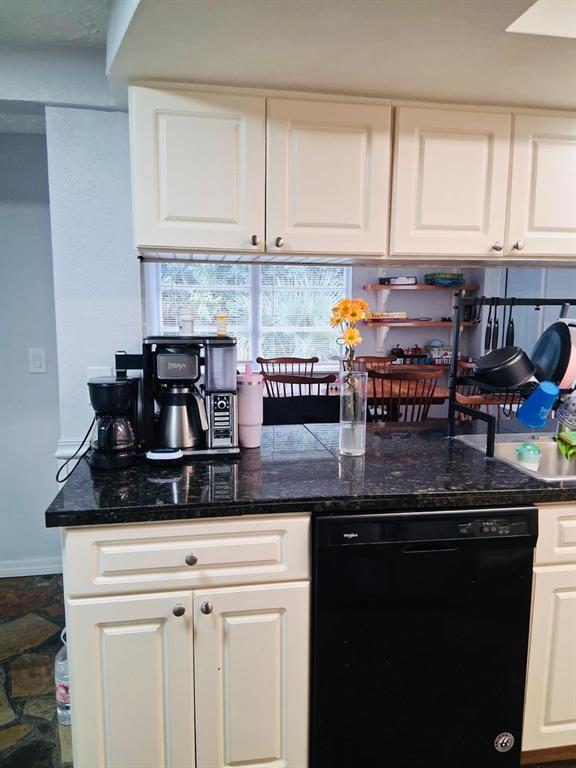 A kitchen features cream cabinets, dark granite countertops, a black dishwasher, and a coffee station — 5344 NANCY LANE, HOLIDAY, FL