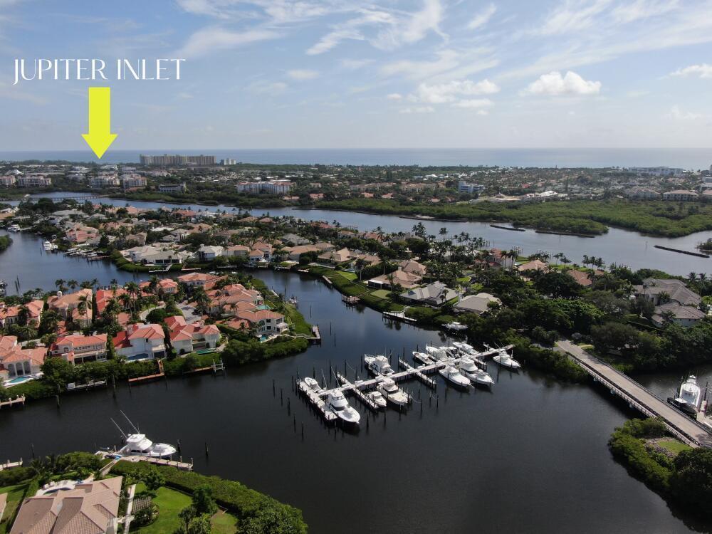 An aerial view shows a residential waterfront community with a marina and a yellow arrow — 3232 Casseekey Island Road, Jupiter FL 33477, JUPITER, FL