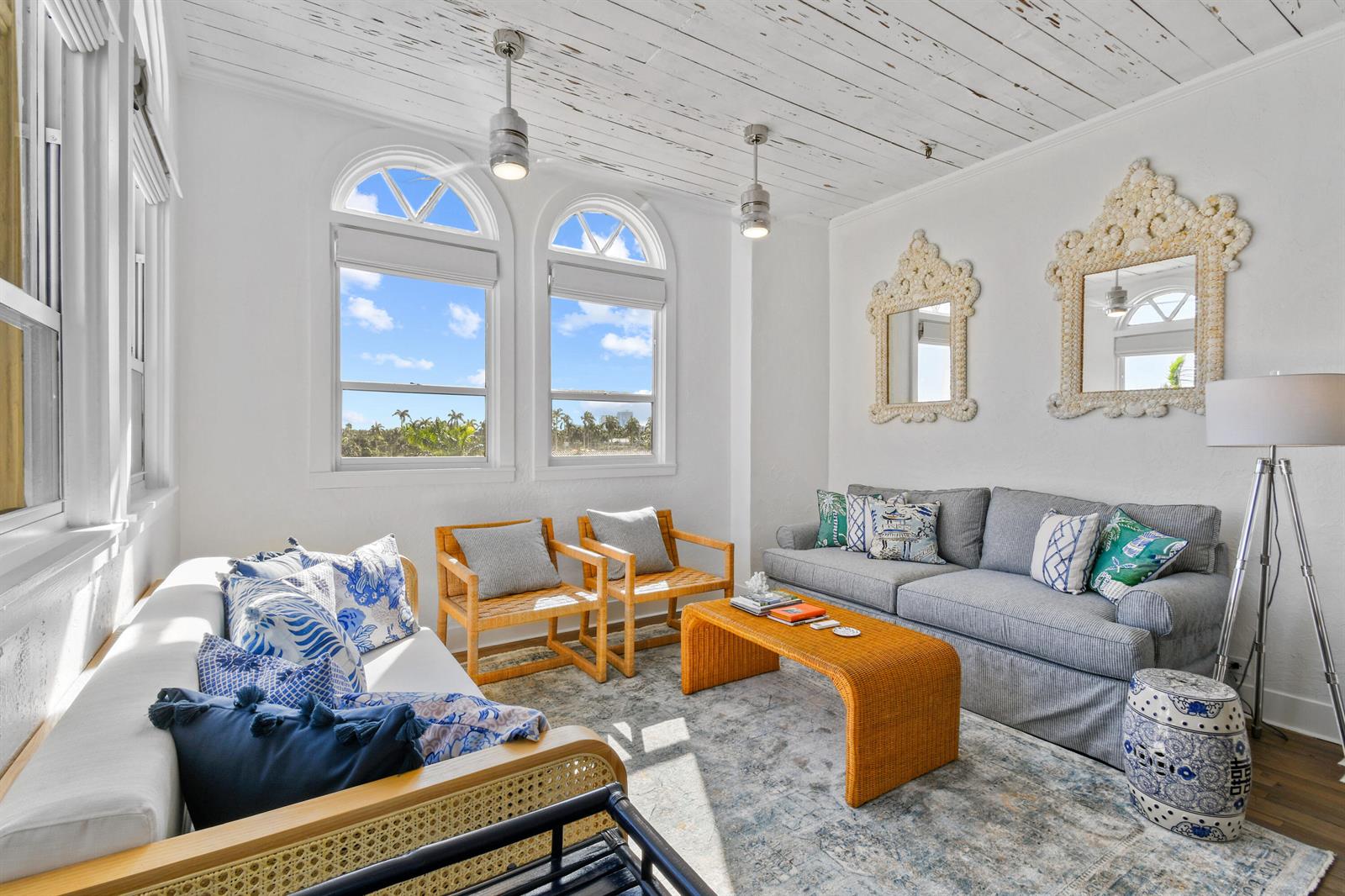 A bright living room features a white plank ceiling, arched windows, and coastal-style furniture — 235 Sunrise Avenue, Palm Beach FL 33480, PALM BEACH, FL