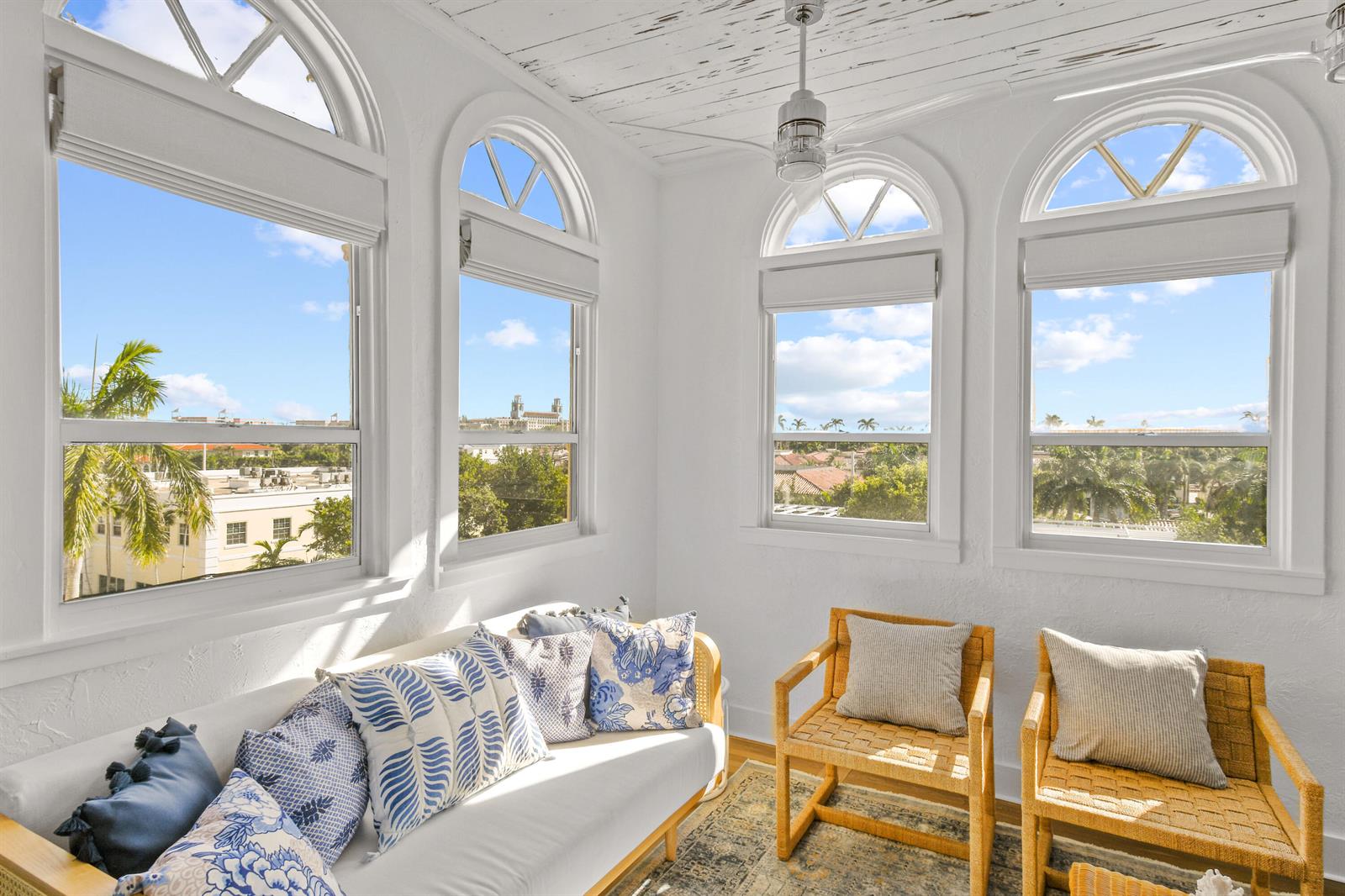 A sunroom features white walls, arched windows, a wood-plank ceiling, and wicker furniture — 235 Sunrise Avenue, Palm Beach FL 33480, PALM BEACH, FL
