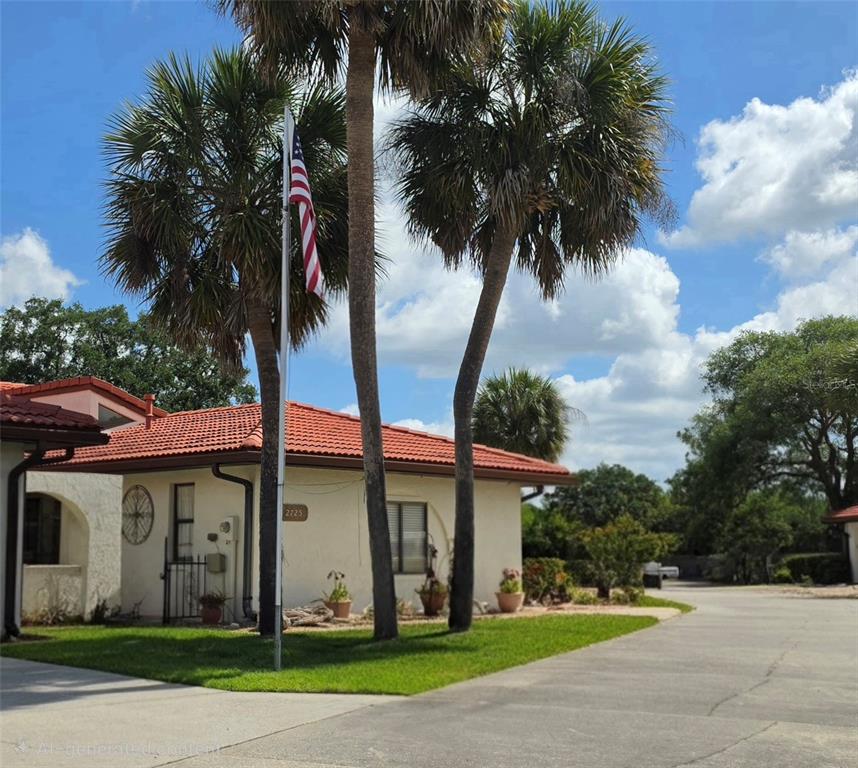A single-story house with a red tile roof and palm trees in the front yard — 2725 CLUBHOUSE DRIVE, LAKE WALES, FL