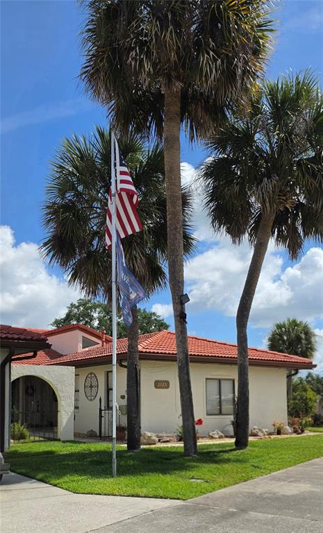 A single-story house with a red tile roof, stucco walls, and a paved driveway — 2725 CLUBHOUSE DRIVE, LAKE WALES, FL