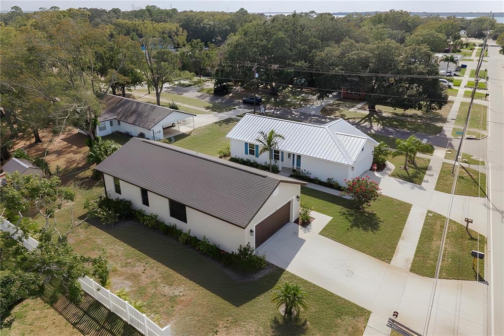 An aerial view shows two adjacent houses with driveways and lawns in a suburban neighborhood — 311 WASHINGTON AVENUE, OLDSMAR, FL