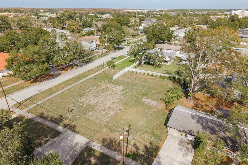 An aerial view shows a vacant, grassy residential lot bordered by a street and houses — 311 WASHINGTON AVENUE, OLDSMAR, FL