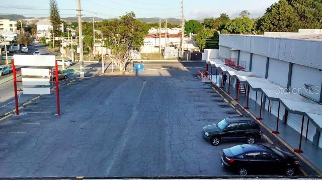 An aerial view of a paved parking lot next to a building with a covered walkway — Ferrocarril St. INT. TORRES ST., PONCE, PR