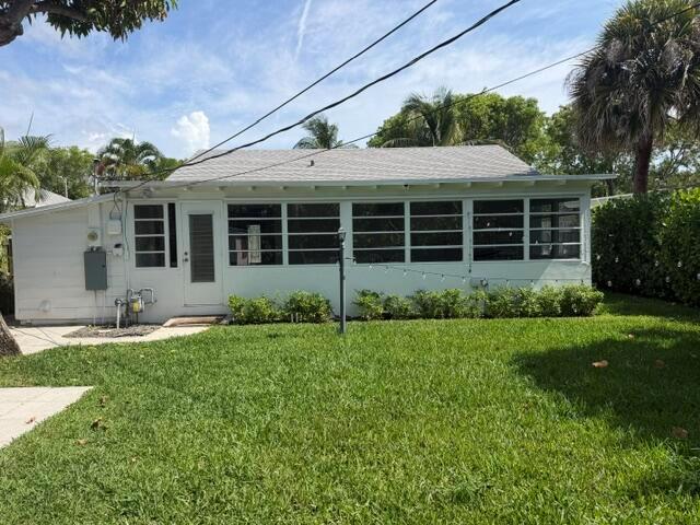 A white single-story house features a screened-in porch and a large green lawn — 211 Princeton Drive, FL 33460, FL