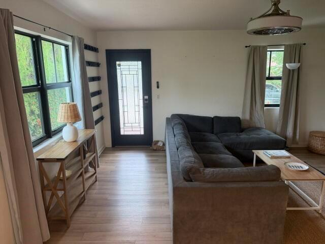A living room features a dark sectional sofa, a console table, and a front door — 211 Princeton Drive, FL 33460, FL