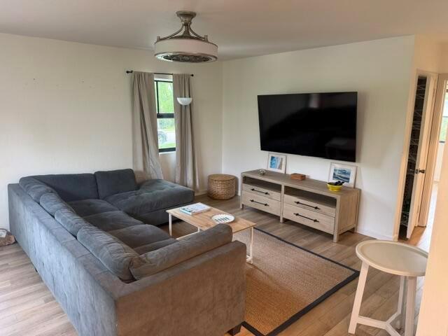 A living room features a gray sectional sofa, a wooden media console, and a television — 211 Princeton Drive, FL 33460, FL
