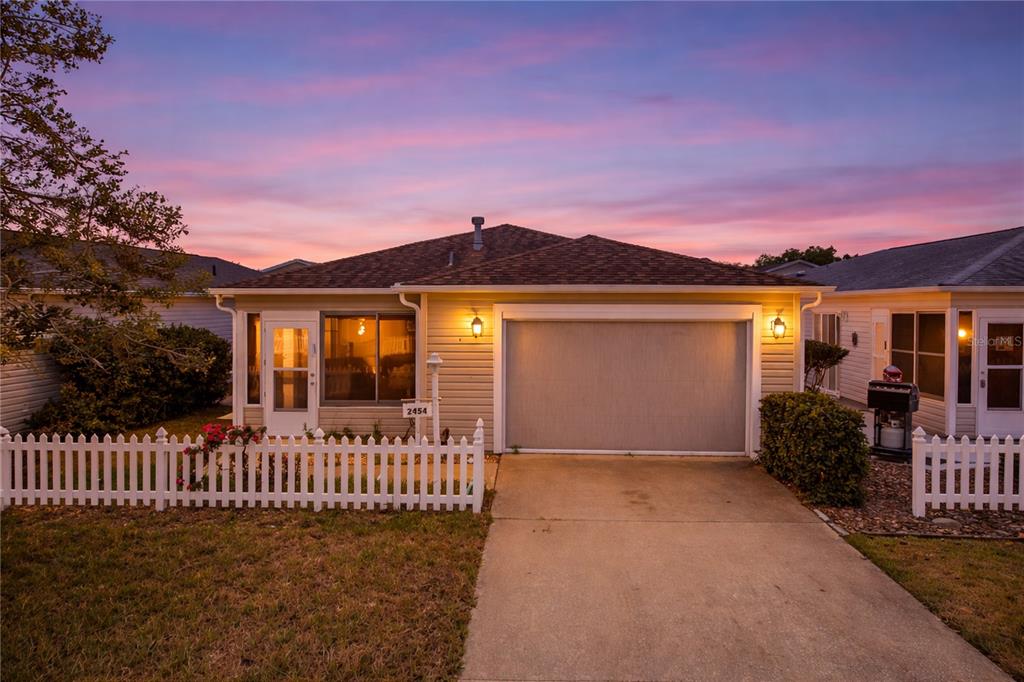 A single-story house with a white picket fence, a garage, and a concrete driveway — 2454 SOUTHERN OAK STREET, THE VILLAGES, FL
