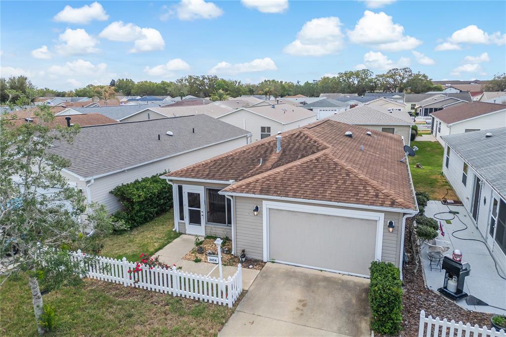 An aerial view shows a single-story house with a brown shingled roof and garage — 2454 SOUTHERN OAK STREET, THE VILLAGES, FL