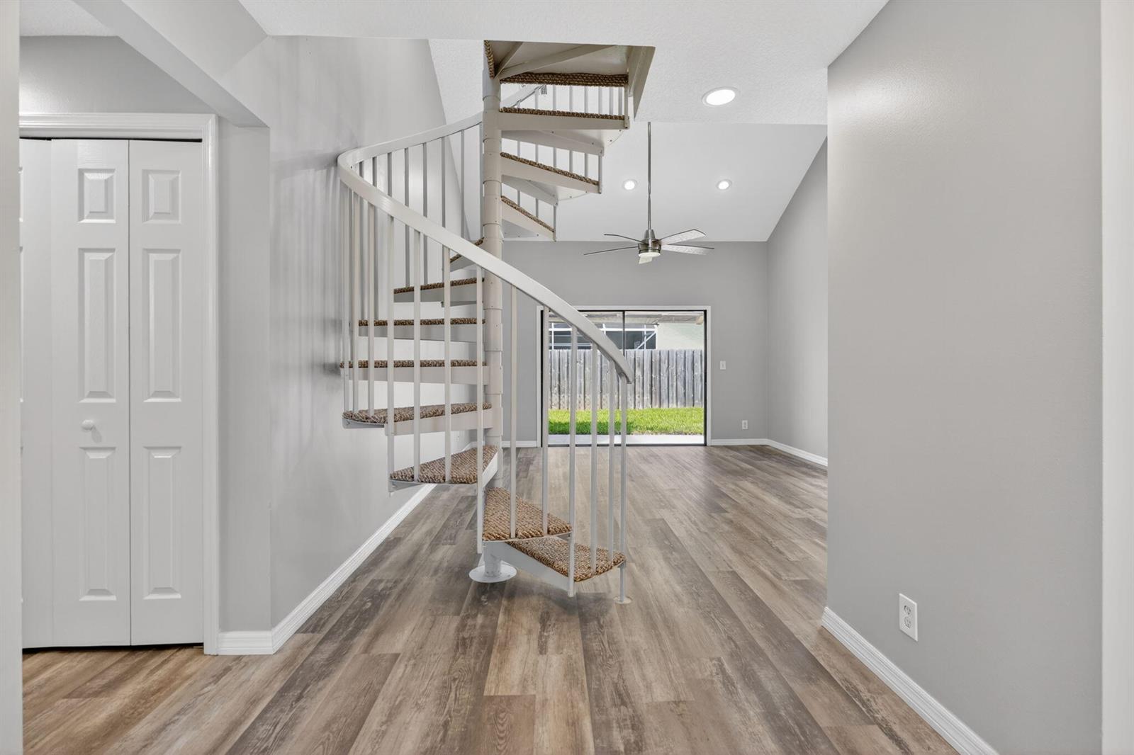 A white spiral staircase stands in a room with light gray walls and wood-look flooring — 6119 Mullin Street, Jupiter FL 33458, JUPITER, FL
