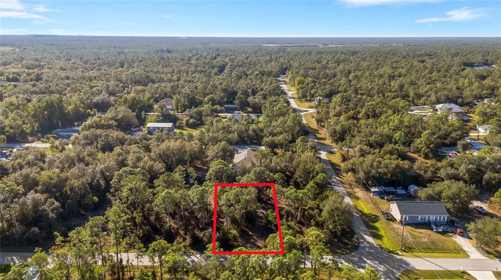 An aerial view shows a rectangular, wooded vacant lot outlined in red near a road — 28149 CHINQUAPIN DRIVE, PUNTA GORDA, FL