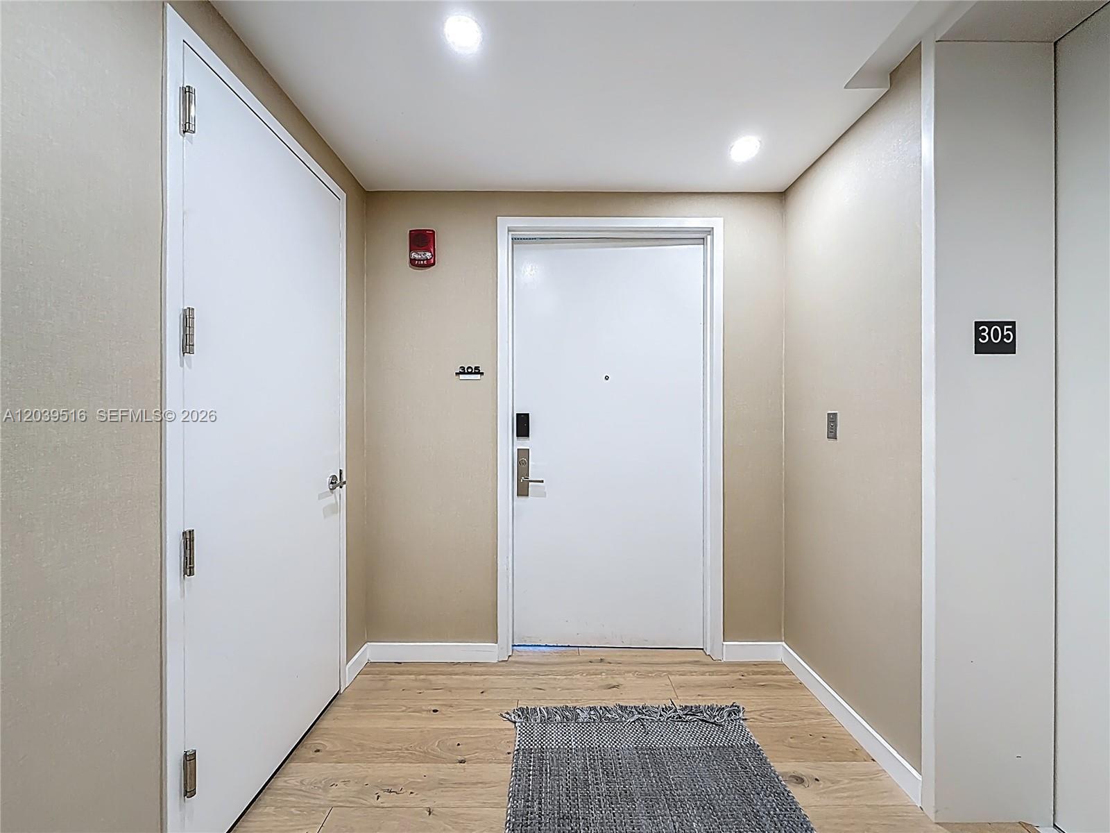 A hallway features light wood flooring, two white doors, and a unit number sign — 350 Ocean Dr # 305N, Key Biscayne FL 33149, KEY BISCAYNE, FL