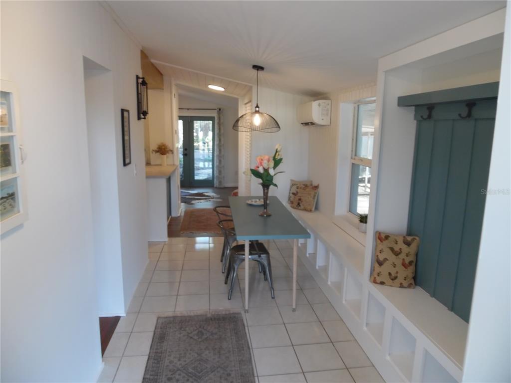 A dining area features a built-in bench, a metal table with chairs, and tiled floors — 5487 70TH WAY N, ST PETERSBURG, FL
