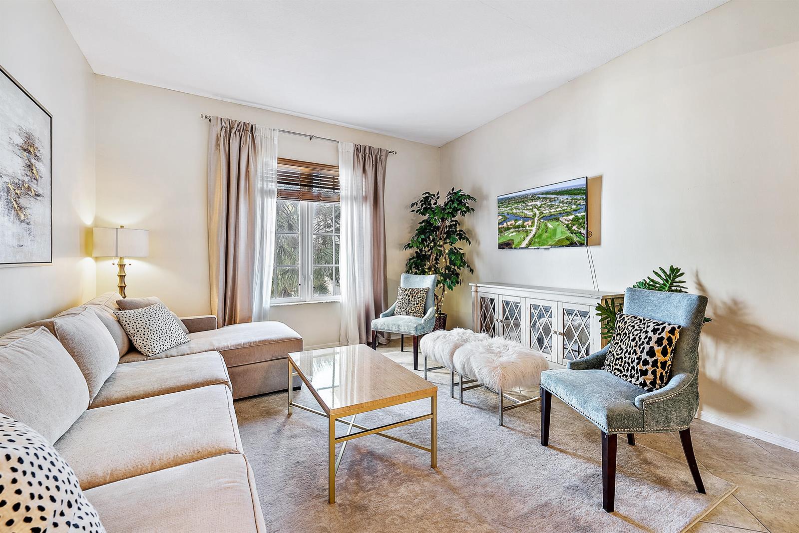 A living room features a beige sectional sofa, two blue armchairs, and a glass coffee table — 1200 Town Center Drive # 225, Jupiter FL 33458, JUPITER, FL