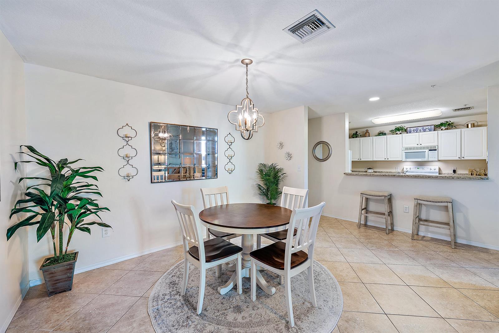 A dining area with a round table and chairs sits adjacent to an open kitchen — 1200 Town Center Drive # 225, Jupiter FL 33458, JUPITER, FL