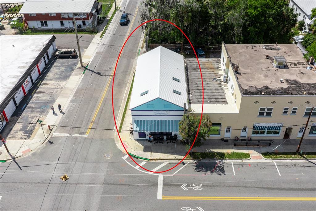 An aerial view shows a narrow, light-colored commercial building with a metal roof and awning — 6880 SE 221ST STREET, HAWTHORNE, FL