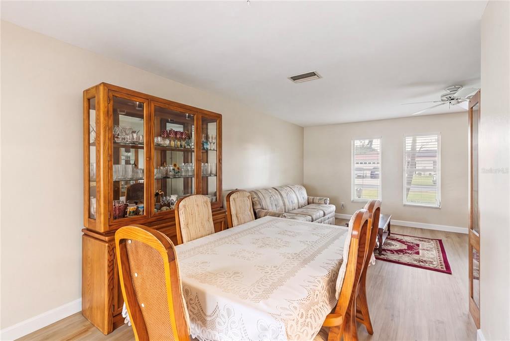 A dining room with a wooden hutch, a table with chairs, and a sofa nearby — 1081 MCFARLAND STREET, DUNEDIN, FL