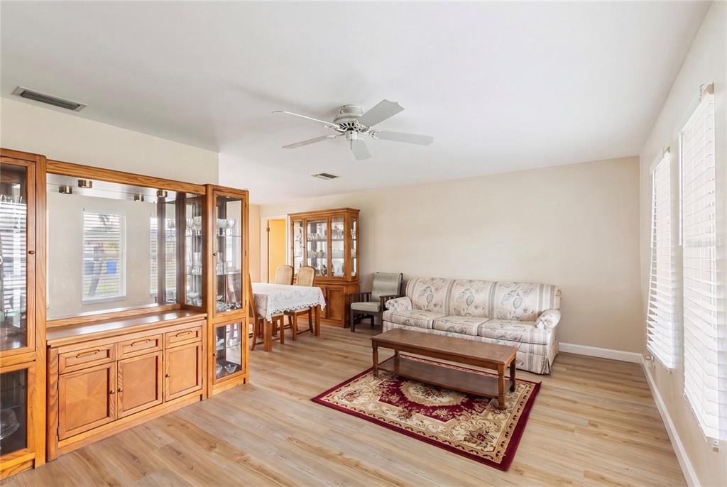 A living and dining area features wood-look flooring, a ceiling fan, and wooden cabinetry — 1081 MCFARLAND STREET, DUNEDIN, FL
