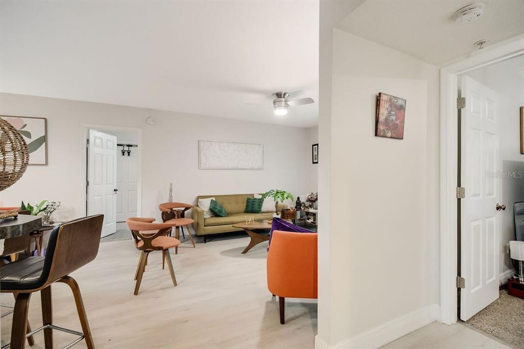 A living room with light wood flooring, a green sofa, and mid-century modern furniture — 738 CREST PINES DRIVE UNIT 726, ORLANDO, FL