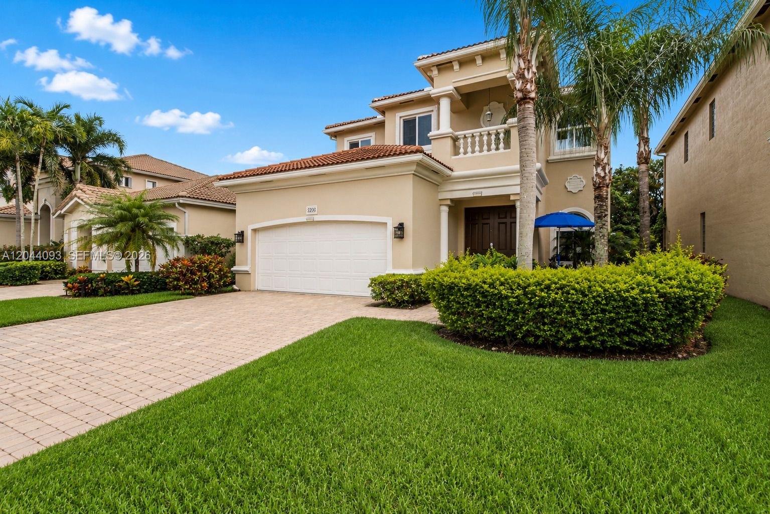 A two-story beige house with a tile roof, a two-car garage, and a landscaped yard — 4200 Key Lime Blvd, Boynton Beach FL 33436, BOYNTON BEACH, FL