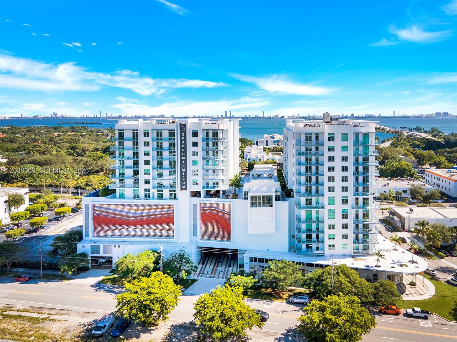 An aerial view shows a modern white residential building with two towers and decorative facades — 3900 Biscayne Blvd # 418, Miami FL 33137, MIAMI, FL