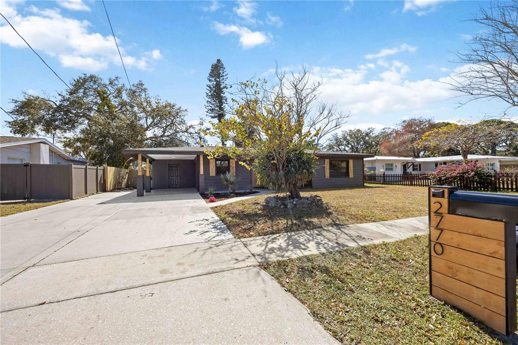 A single-story house with a gray exterior, a carport, and a wooden mailbox post — 2770 WOOD STREET, SARASOTA, FL