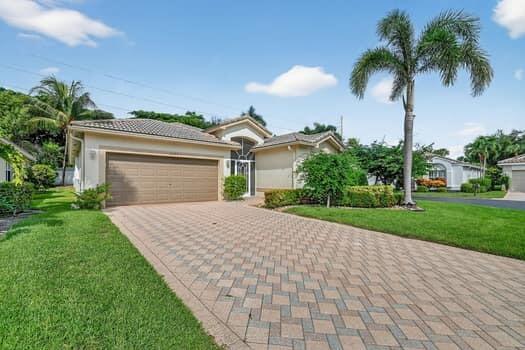 A single-story house with a paved driveway, a two-car garage, and a palm tree — 10299 Utopia Circle W, Boynton Beach FL 33437, BOYNTON BEACH, FL