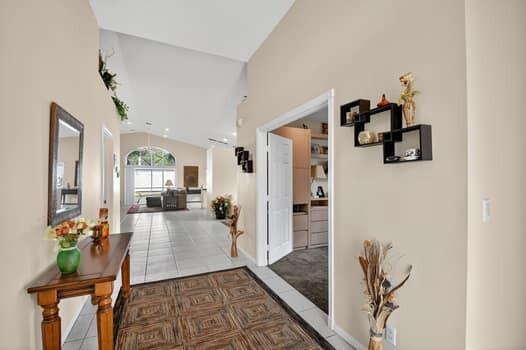 A view from a foyer looking into a living room with tile floors and vaulted ceilings — 10299 Utopia Circle W, Boynton Beach FL 33437, BOYNTON BEACH, FL