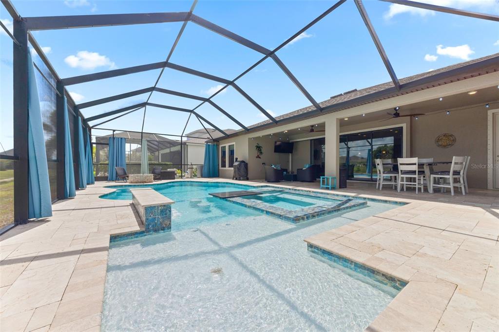 A screened-in patio features a swimming pool with a spa and a covered dining area — 5416 LIMELIGHT DRIVE, APOLLO BEACH, FL