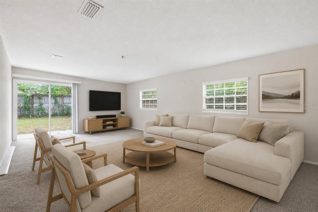 This is a virtually staged living room with a sectional sofa, chairs, and sliding doors — 3519 COLLEGE STREET, JACKSONVILLE, FL