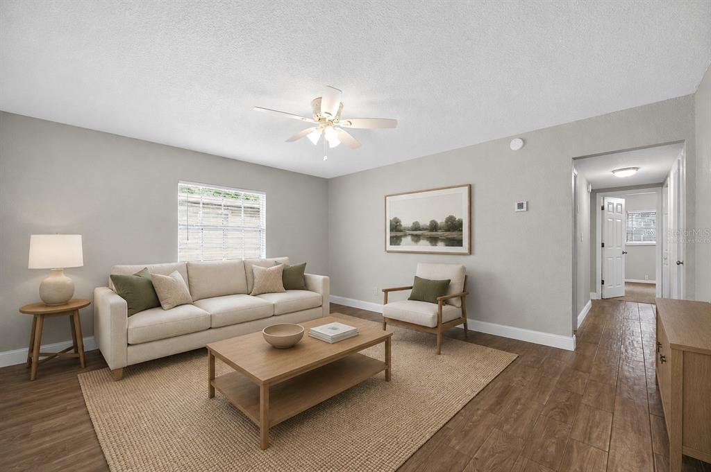 A living room features a beige sofa, wooden coffee table, armchair, and light wood flooring — 3519 COLLEGE STREET, JACKSONVILLE, FL