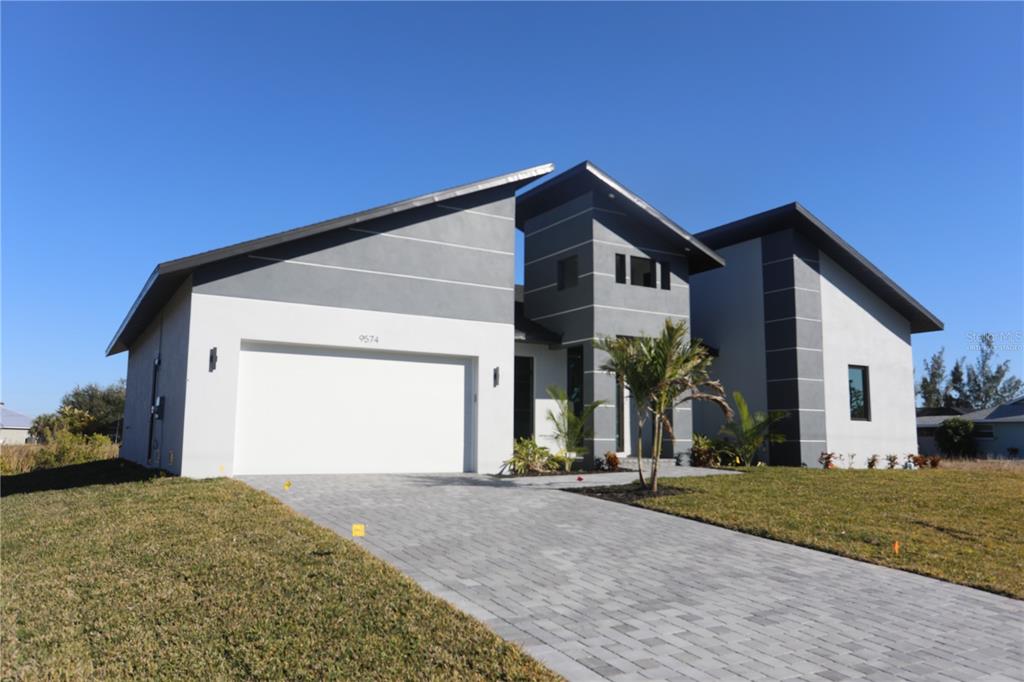 A modern two-story house with a gray and white exterior and a paved driveway — 9574 SALT LAKE STREET, PORT CHARLOTTE, FL