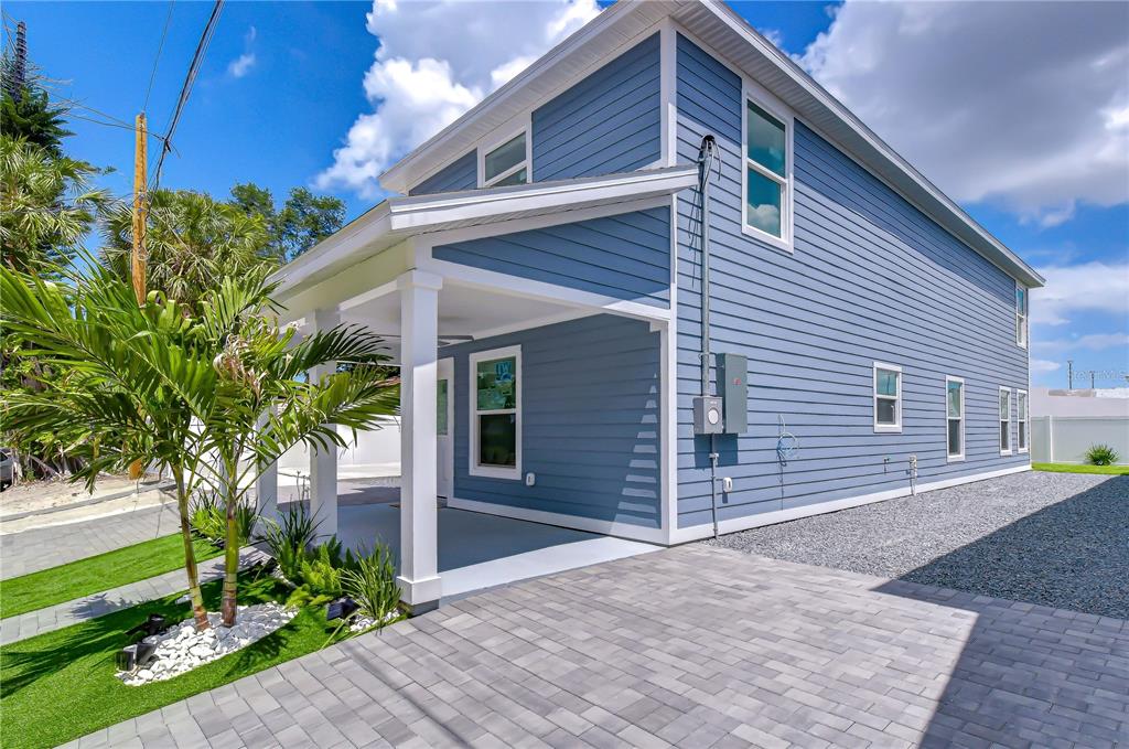 A blue-sided two-story house features a covered front porch and a paved driveway — 222 8TH AVENUE DRIVE W, BRADENTON, FL