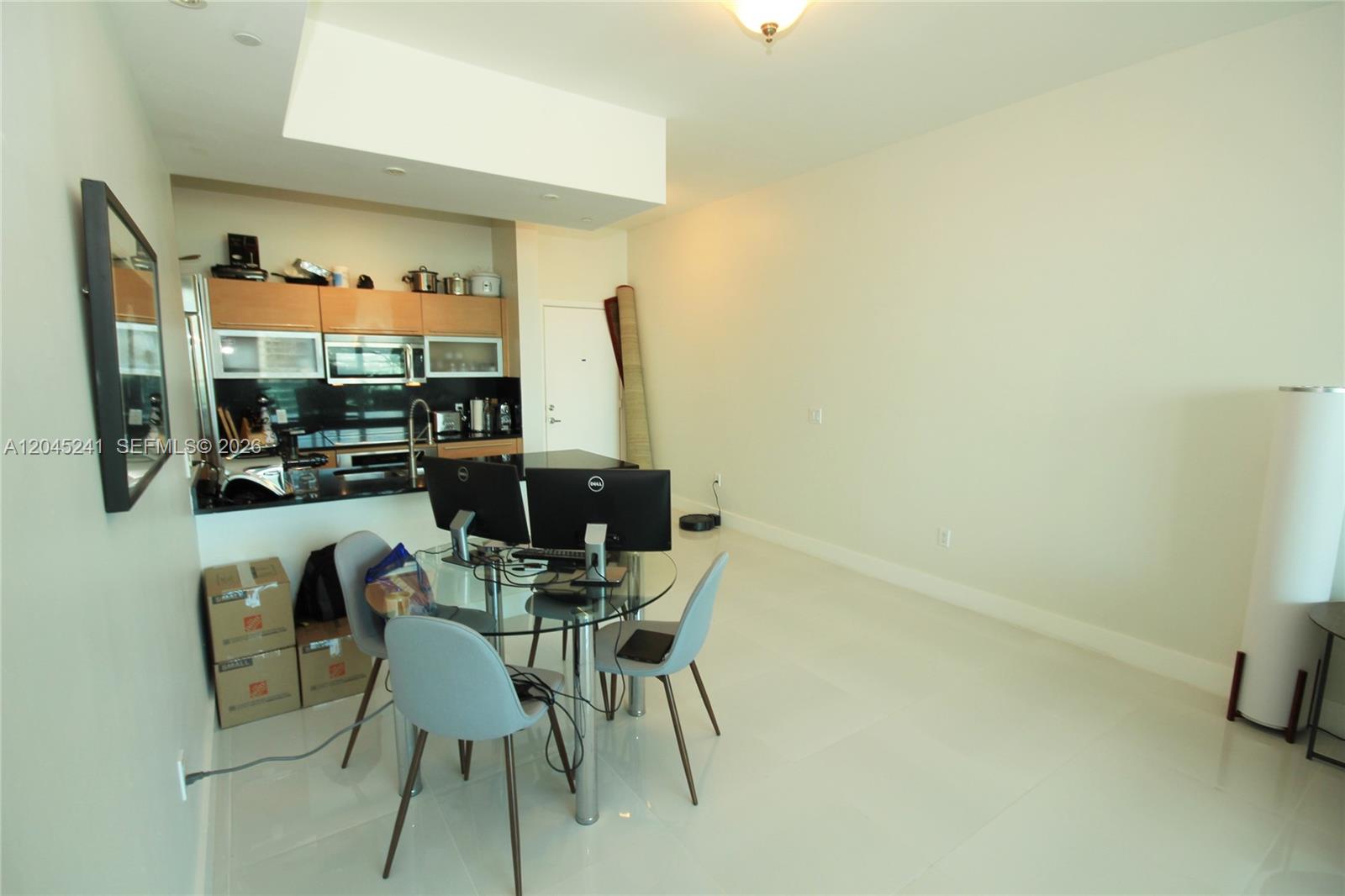 A small dining area features a glass table, two chairs, and an adjacent kitchen — 950 Brickell Bay Dr # 5000, Miami FL 33131, MIAMI, FL