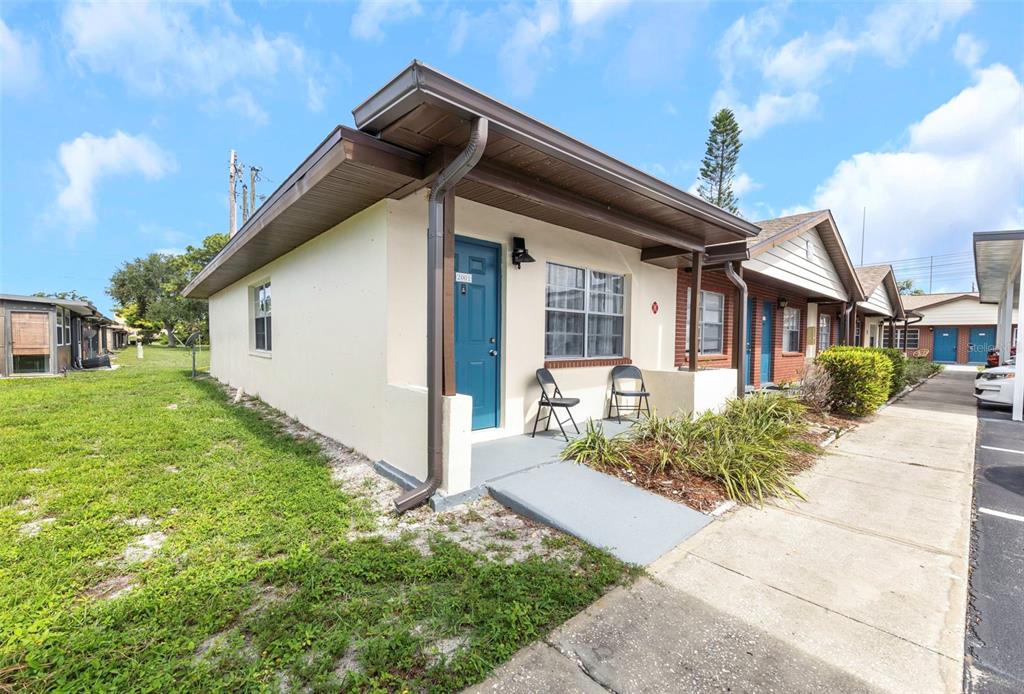 A single-story residential unit with a blue door, a small porch, and a concrete walkway — 24862 US HIGHWAY 19 N UNIT 2001, CLEARWATER, FL