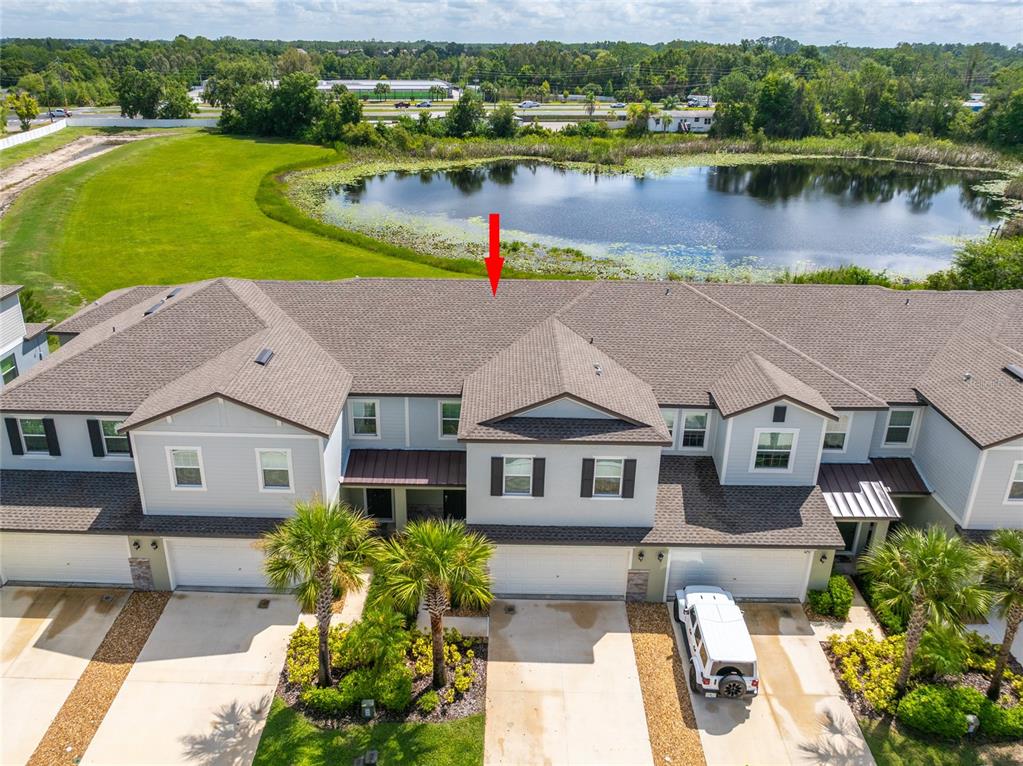 An aerial view shows the roof and front facade of a multi-unit townhouse complex — 6262 SHINER STREET, LAND O LAKES, FL