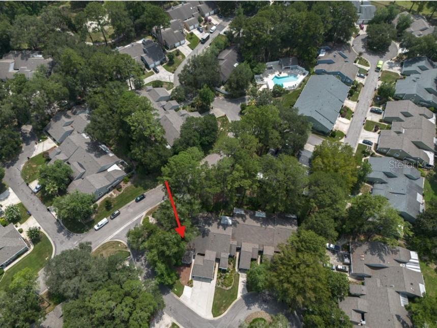 An aerial view shows a residential townhouse complex surrounded by trees and a swimming pool — 1013 NW 124TH DRIVE, NEWBERRY, FL