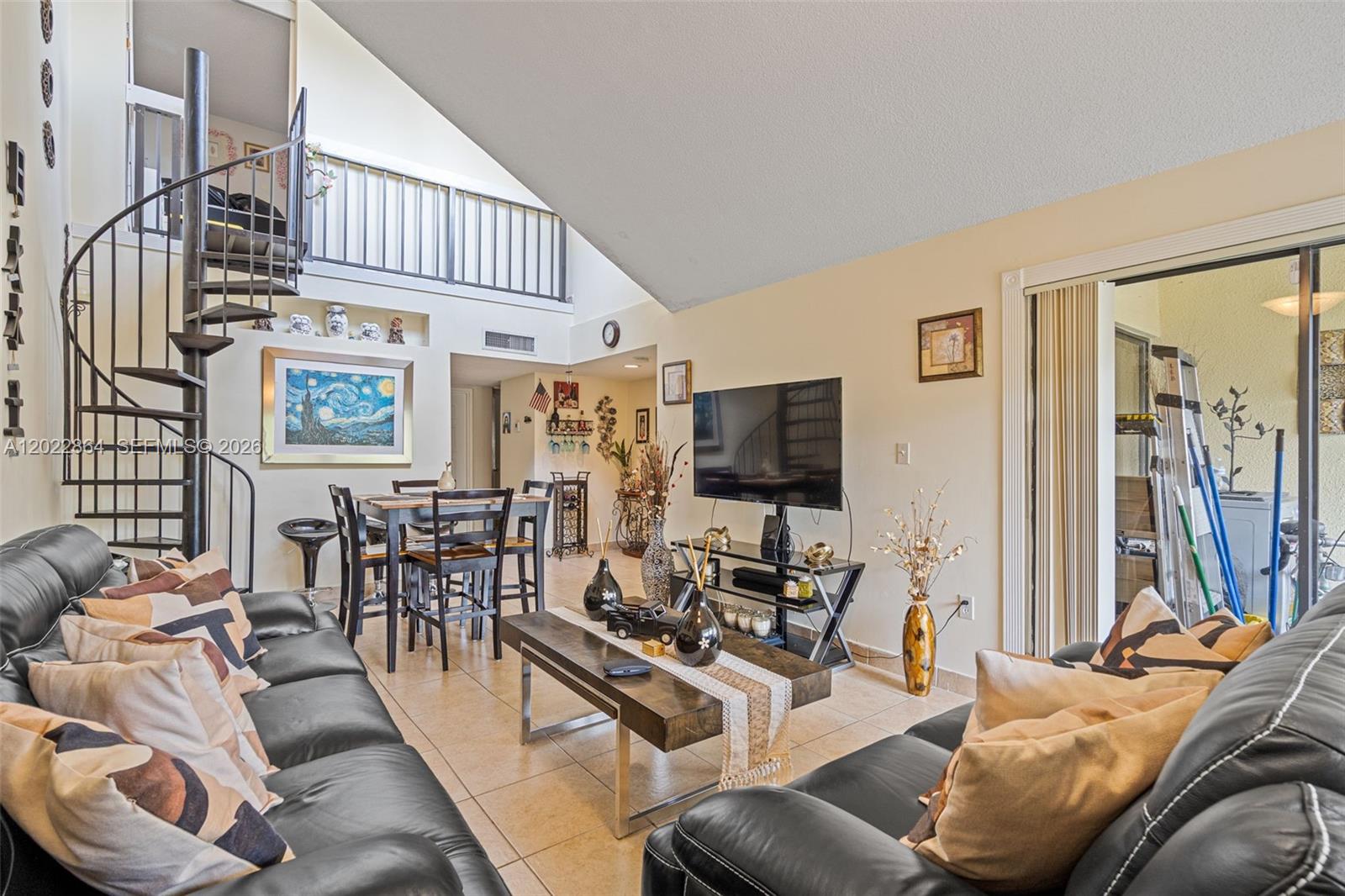 A living room features a spiral staircase, tile flooring, and a dining area — 12927 SW 88th Ln # A205, Miami FL 33186, MIAMI, FL