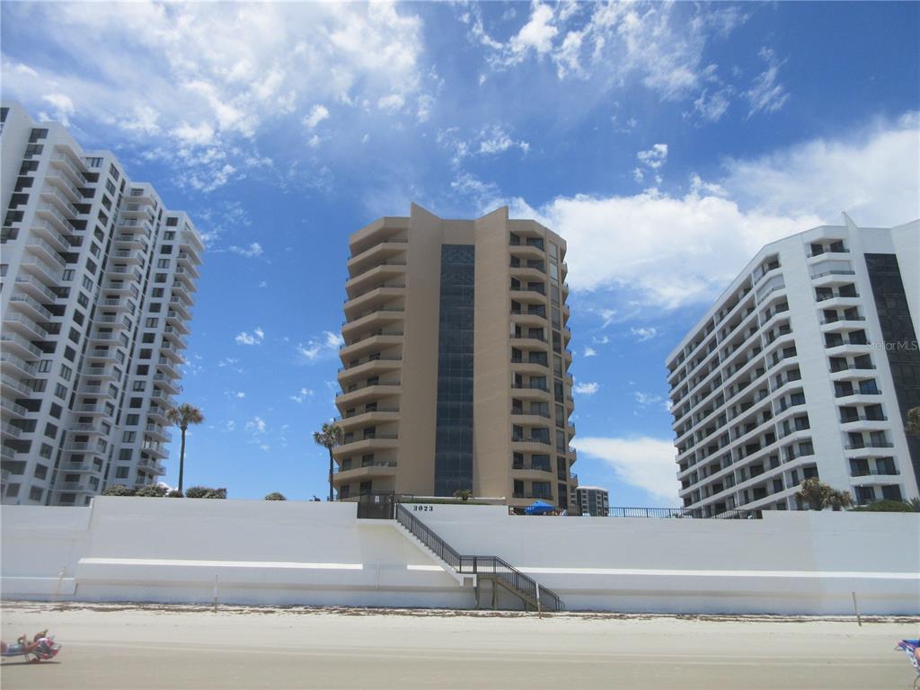 Three high-rise condominium buildings stand behind a white retaining wall on a sandy beach — 3023 S ATLANTIC AVENUE UNIT 2070, DAYTONA BEACH, FL